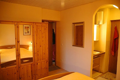 Doppelbett, großer Kleiderschrank, Spiegel und der Blick zum Waschbecken